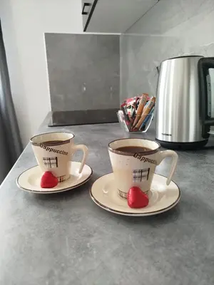 two cups on plates with hearts on them on a counter at Apartman David in Jajce