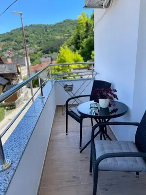 a table and chairs on a balcony with a view at Apartman David in Jajce