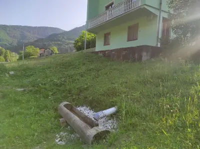 a pipe laying in the grass next to a house at Apartman Džanan in Jajce