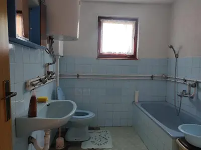 a bathroom with a sink and a tub and a toilet at Apartman Džanan in Jajce