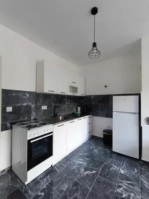 a kitchen with white cabinets and a white refrigerator at TriM Apartments in Travnik