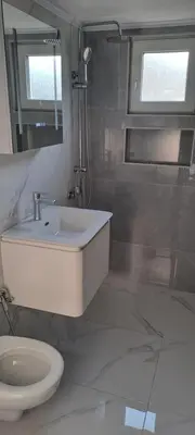 a bathroom with a sink and a toilet and a mirror at Apartman Aydan in Jajce