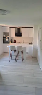 a kitchen with a table and two stools in it at Apartman Aydan in Jajce