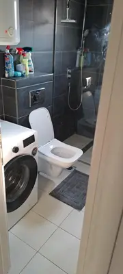 a bathroom with a washing machine and a toilet at Apartman Aydan in Jajce