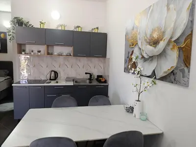 a kitchen with a white table and a painting on the wall at Relax 2 in Bosanska Dubica