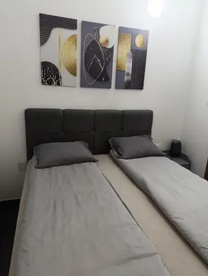 two beds in a room with three pictures on the wall at Relax 2 in Bosanska Dubica