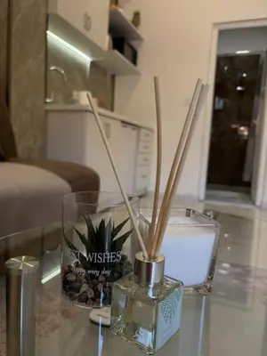 a glass vase with sticks in it on a table at SM studio apartman in Banja Luka