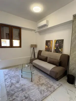 a living room with a couch and a glass table at SM studio apartman in Banja Luka