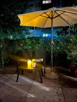 a table with a candle and an umbrella at SM studio apartman in Banja Luka