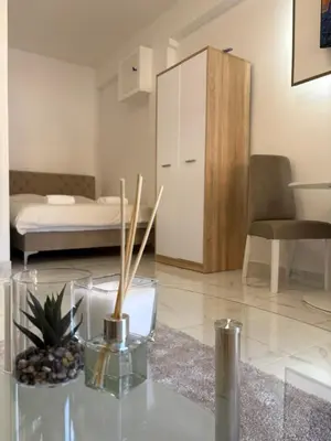 a living room with a bed and a glass table at SM studio apartman in Banja Luka
