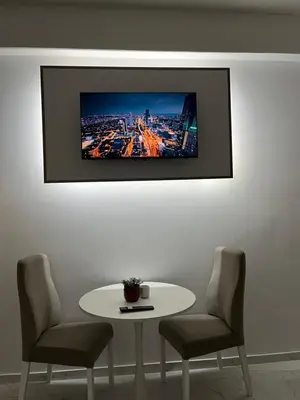 a table with two chairs and a tv on a wall at SM studio apartman in Banja Luka
