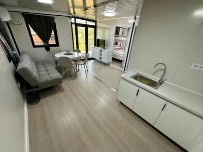 a kitchen and dining room with a couch and a table at Rama holiday resort in Prozor