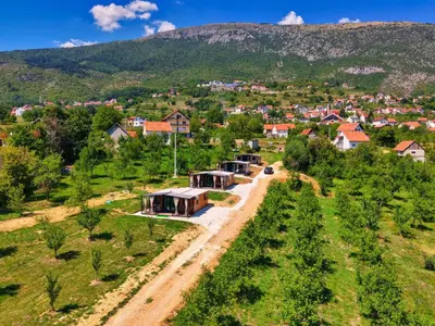 an aerial view of a village with a mountain in the background at Rama holiday resort in Prozor