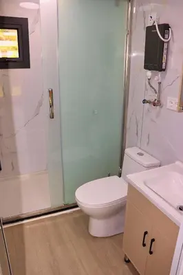 a bathroom with a toilet and a shower and a sink at Rama holiday resort in Prozor