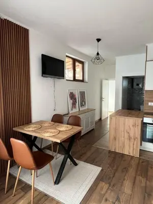 a living room with a table and a kitchen at Apartman Palazzo in Bosanska Krupa