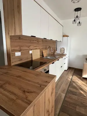 a kitchen with white cabinets and a wooden counter top at Apartman Palazzo in Bosanska Krupa