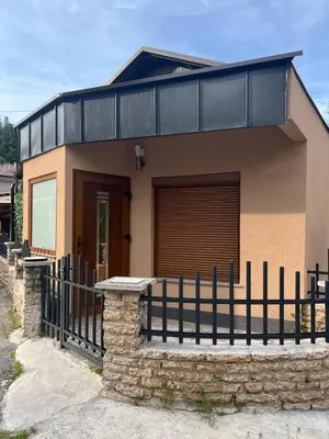a small house with a fence in front of it at Apartman Palazzo in Bosanska Krupa