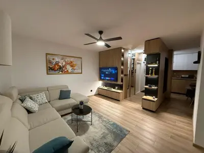 a living room with a white couch and a tv at Central Spot BL in Banja Luka