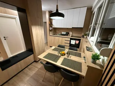 a small kitchen with a wooden table and chairs at Central Spot BL in Banja Luka