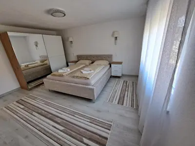 a bedroom with two beds and a large mirror at Apartman Amela Deluxe in Kulen Vakuf