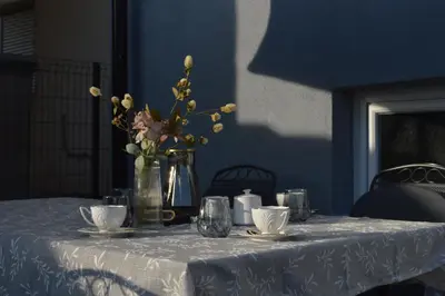 a table with a vase of flowers on it at Apartman Amela Deluxe in Kulen Vakuf