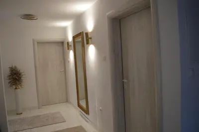 an empty hallway with a door and a mirror at Apartman Amela Deluxe in Kulen Vakuf