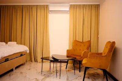 a hotel room with a bed and a table and chairs at Apartman 101 in Visoko
