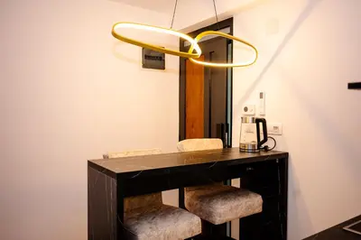 a room with a desk with two chairs and a chandelier at Apartman 101 in Visoko