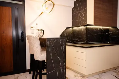 a kitchen with black marble countertops and a desk at Apartman 101 in Visoko