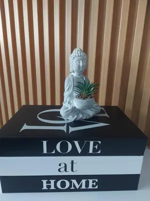 a statue of a buddha sitting on a table at Apartman Nina Residence Banja Luka in Banja Luka