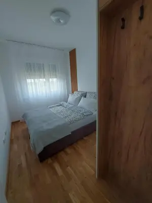 a bedroom with a bed and a large mirror at Apartman Nina Residence Banja Luka in Banja Luka