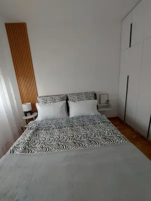a bed with a black and white comforter and two pillows at Apartman Nina Residence Banja Luka in Banja Luka
