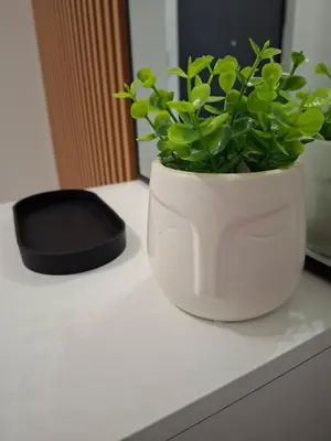 a white vase sitting on a counter with a plant at Apartman Nina Residence Banja Luka in Banja Luka