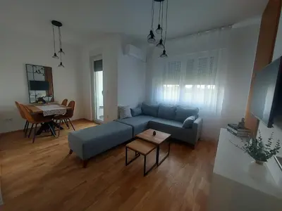 a living room with a blue couch and a table at Apartman Nina Residence Banja Luka in Banja Luka