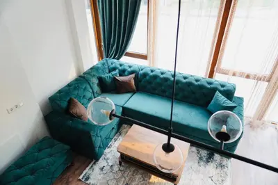 a blue couch in a living room with a window at HANA Superior Apartment in Kakanj