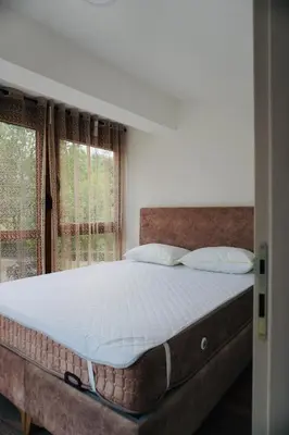a bedroom with a large bed in front of a window at HANA Superior Apartment in Kakanj