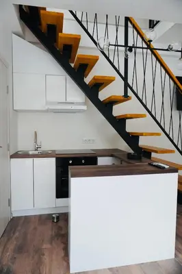 a kitchen with white cabinets and a wooden staircase at HANA Superior Apartment in Kakanj