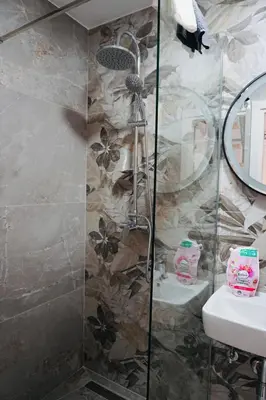 a shower with a glass door next to a sink at HANA Superior Apartment in Kakanj