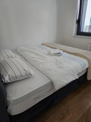 an unmade bed in a room with a window at Divna Besplatan parking in Banja Luka