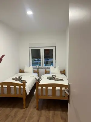 two beds in a room with a window at Stan na dan Ana in Prozor