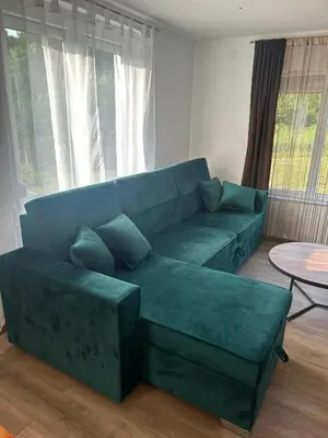 a living room with a green couch and a table at Vila Fina in Laktaši