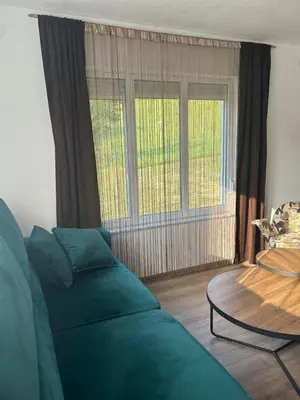 a living room with a couch and two windows at Vila Fina in Laktaši