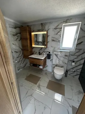 a bathroom with a sink and a toilet and a mirror at Vila Fina in Laktaši