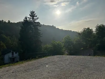 a gravel road with a house and trees in the background at Vila Fina in Laktaši