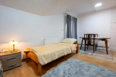 a bedroom with a bed and a desk and a table at Apartmani Božur in Bosanska Gradiška