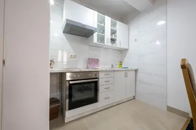 a kitchen with white cabinets and a stove at Apartmani Božur in Bosanska Gradiška