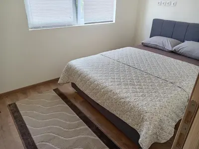 a bed sitting in a bedroom with a window at apartman Tomić in Glamoč