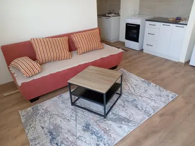 a living room with a red couch and a coffee table at apartman Tomić in Glamoč