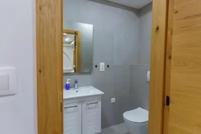 a bathroom with a sink and a toilet and a mirror at Motel Aqua Kozarac in Kozarac