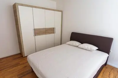 a bedroom with a white bed and a cabinet at Motel Aqua Kozarac in Kozarac